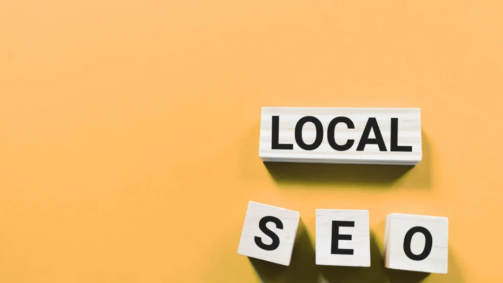 Wooden blocks spelling 'LOCAL SEO' on a yellow background, showcasing the importance of Local SEO Services for Businesses.