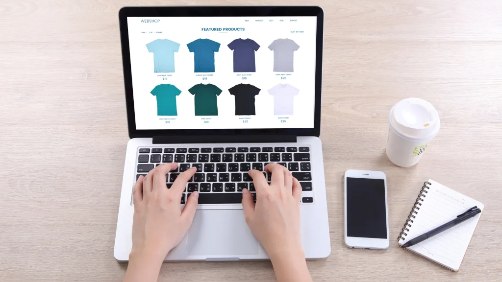 Hands typing on a laptop with an online clothing store, illustrating SEO for Ecommerce Websites.