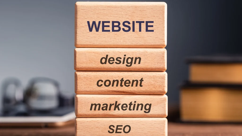 Wooden blocks with "Website", "Design", "Content", "Marketing", and "SEO" stacked together, symbolizing website development.