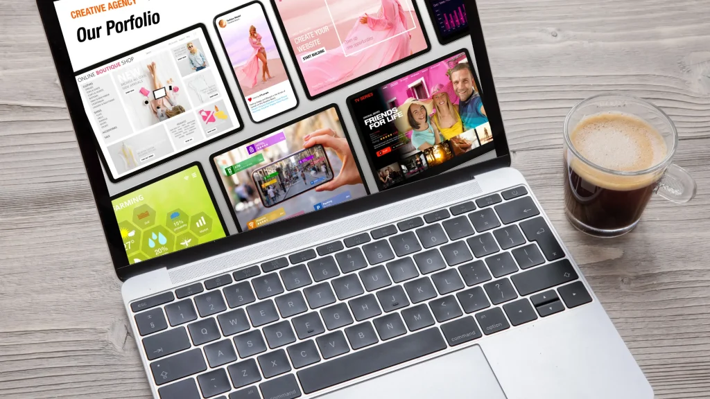 A laptop screen showing a creative agency portfolio with various website designs.
